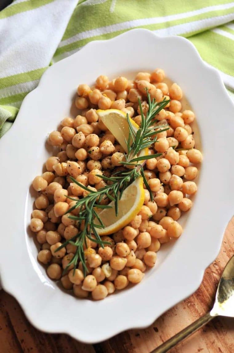 birds eye view of gluten free lemon rosemary chickpeas from scratch garnished with fresh lemon wedges served in a large white bowl
