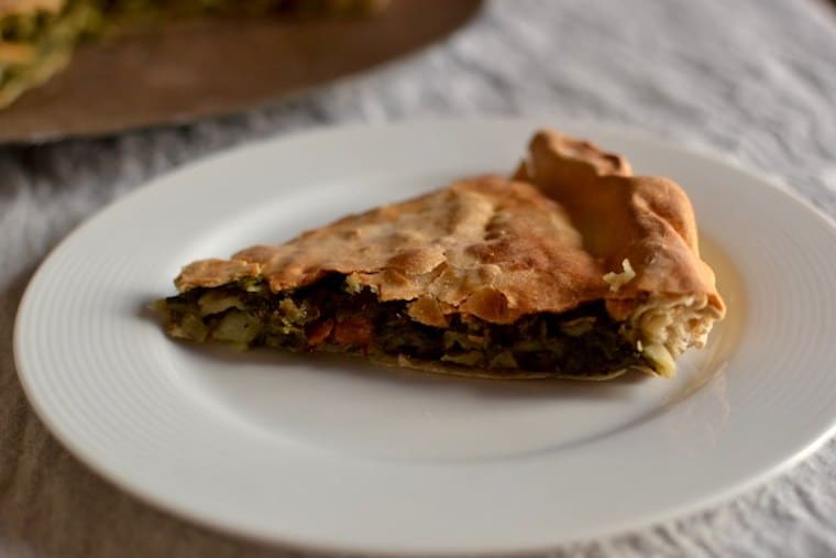 slice of homemade vegan greek spinach pie on a white plate