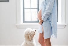 Abbey Sharp, pregnant, standing in front of her dog.