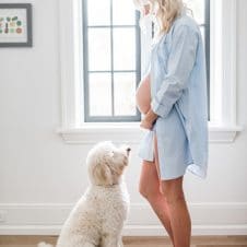 Abbey Sharp, pregnant, standing in front of her dog.