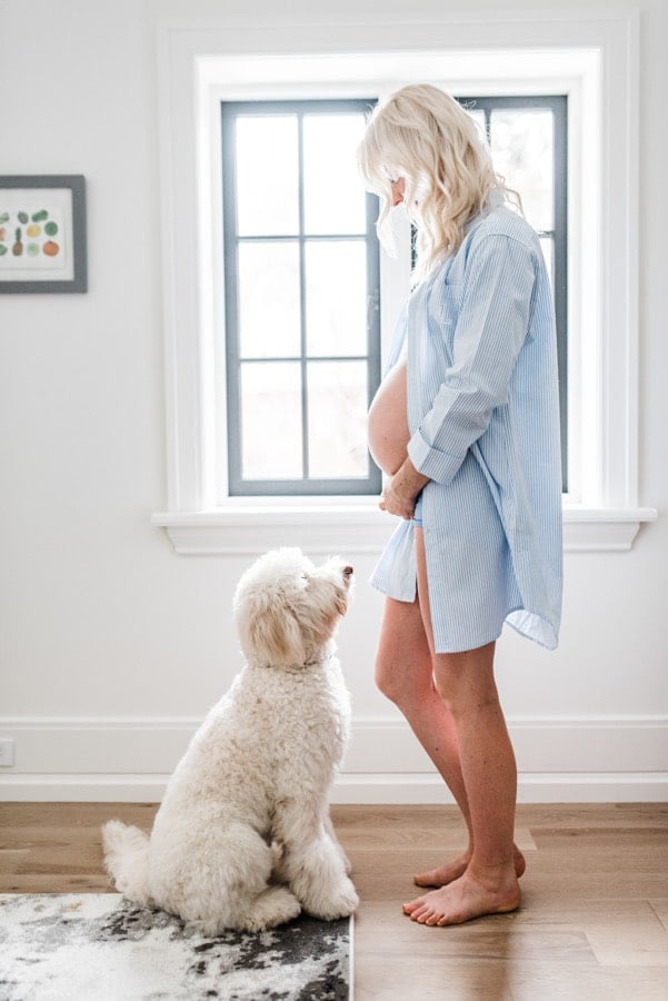 Abbey Sharp, pregnant, standing in front of her dog.