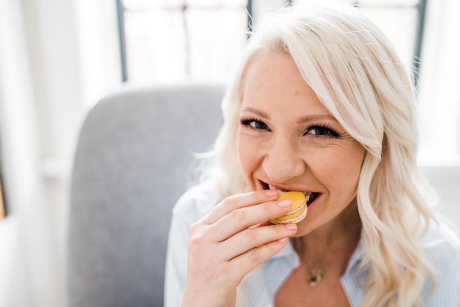 Woman eating a macaroon for pregnancy food safety. 