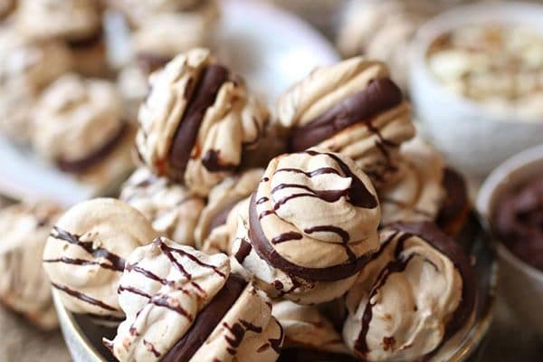 A pinterest image of a bowl with almond cherry chocolate meringue cookies with a chocolate ganache with the overlay text "gluten free | dairy free almond cherry chocolate meringue cookies | passover."