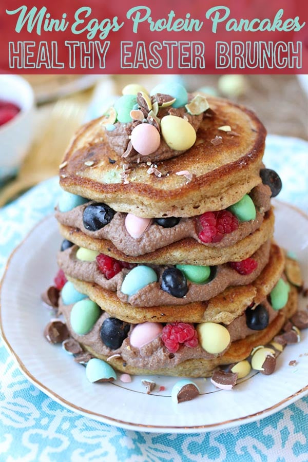 A stack of mini egg pancakes with raspberries and blueberries in between.