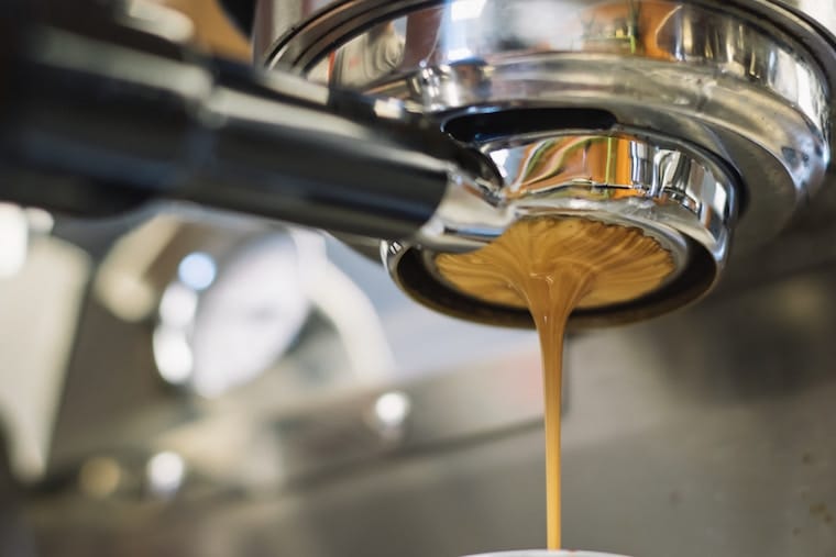 An espresso machine making coffee for pregnancy food safety.