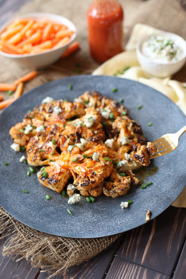 Gold fork digging into buffalo cauliflower steaks.