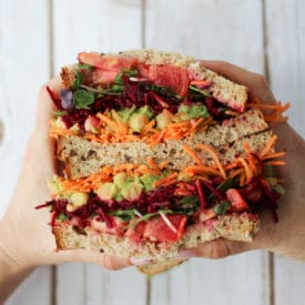 Hand holding two veggie sandwich halves