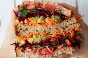 Hand holding two veggie sandwich halves
