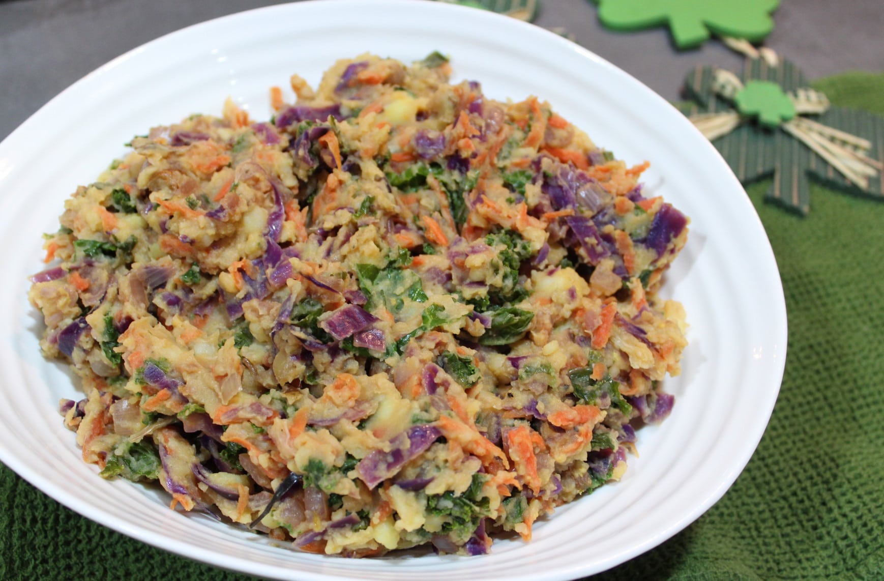 birds eye view of vegan rainbow colcannon for st. patrick's day in a large white bowl