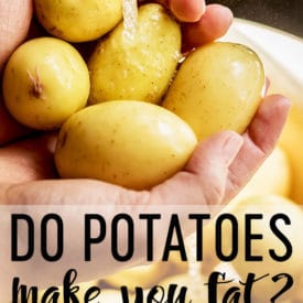 Two hands holding yellow flesh potatoes under running water.