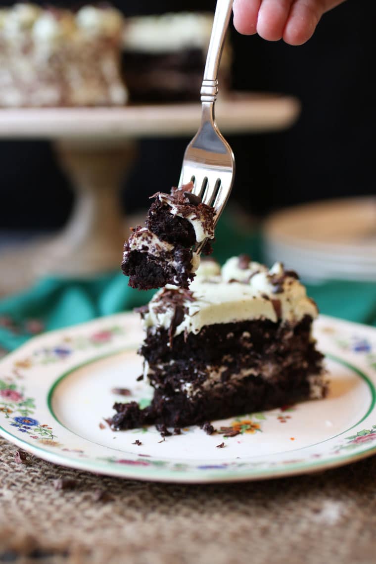 A slice of chocolate cake with a piece on a fork.