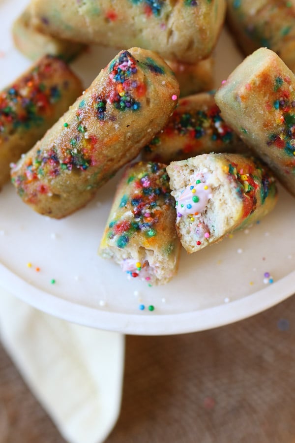 birds eye view of rainbow twinkies with strawberries protein cream filling on a white plate