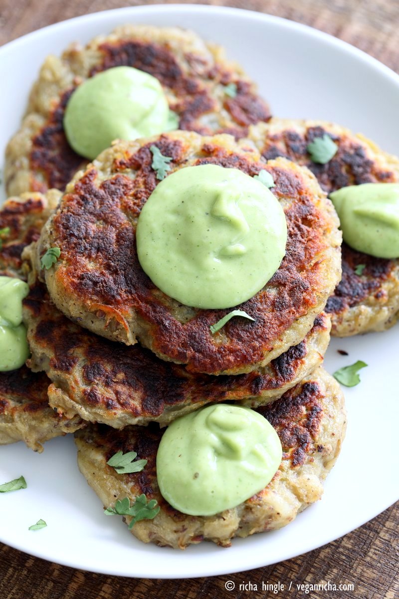 birds eye view of a stack of vegan irish potato cakes garnished with green avocado basil ranch