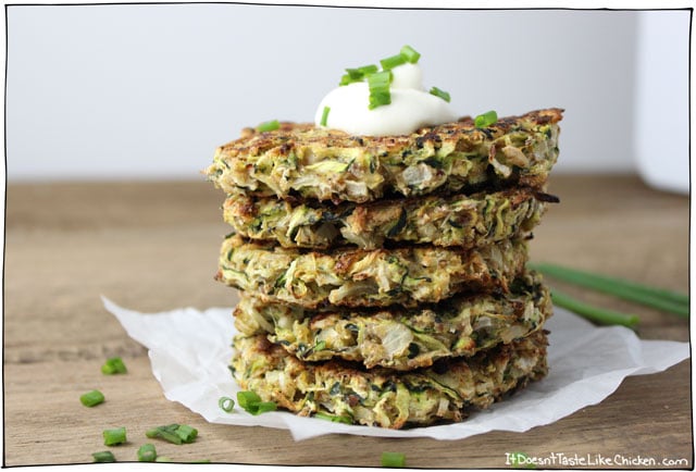 close up of a stack of vegan baked zucchini fritters for st patricks day garnished with fresh herbs