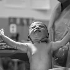 A baby being held by a doctor.