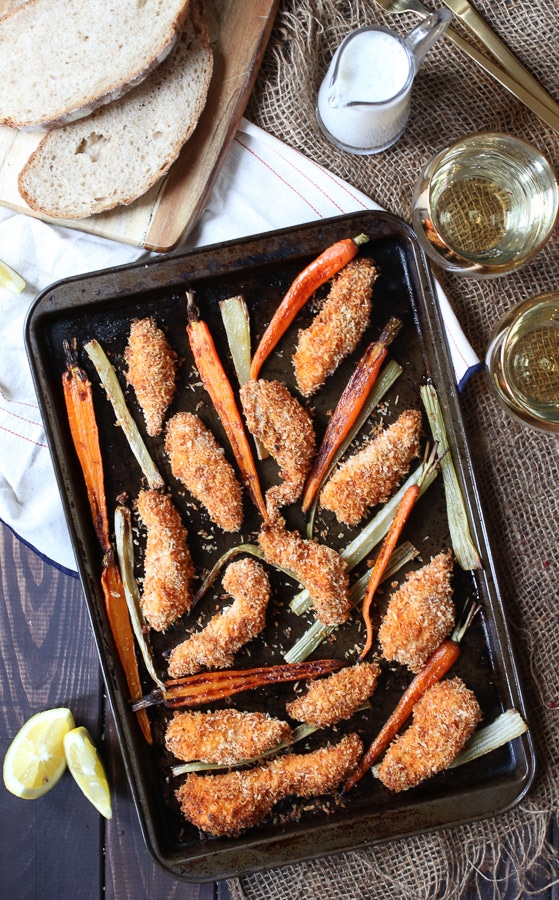 Overhead image of a sheet pan of buffalo chicken fingers and carrots.