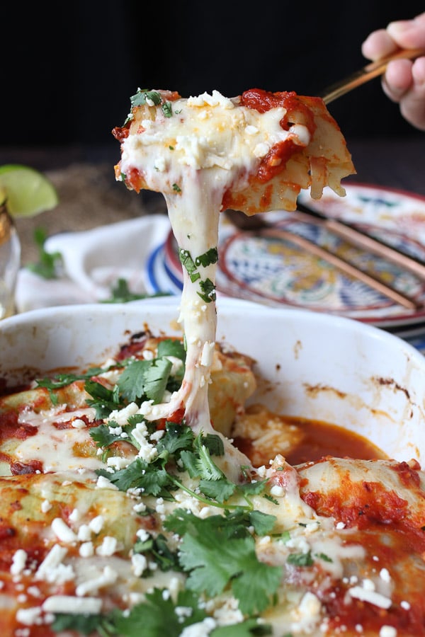 Spoon holding a serving of cheesy low carb enchiladas. 