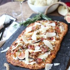 Fig, apple and onion cauliflower pizza on a serving platter.