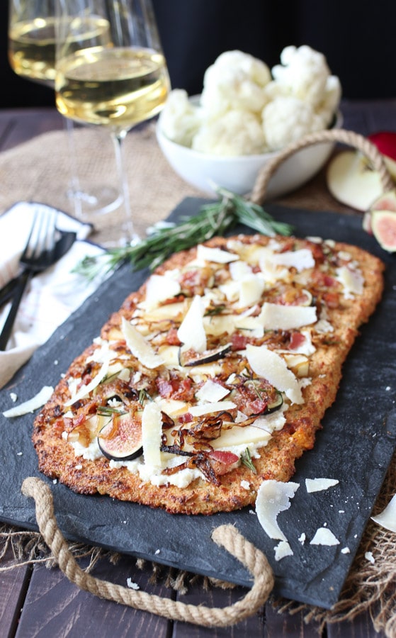 Fig, apple and onion cauliflower pizza on a serving platter.