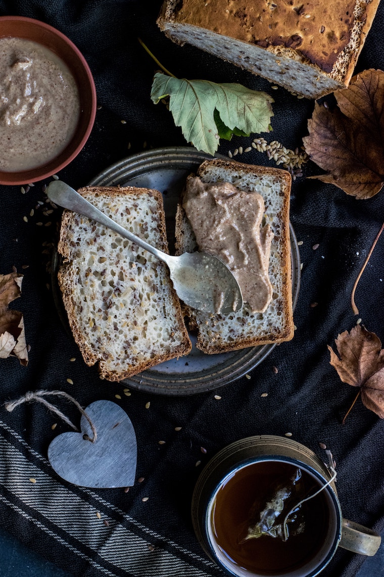 Two slices of a loaf with nut butter on top.