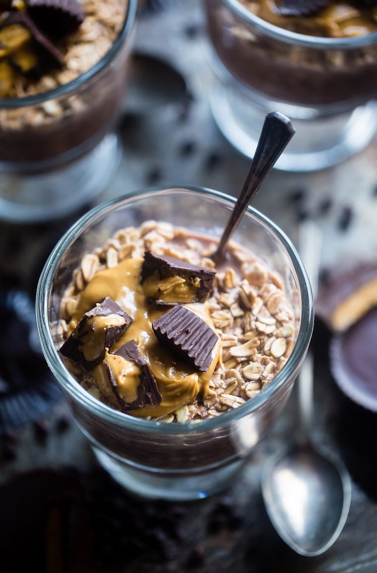 Oatmeal in a glass bowl topped with chocolate and peanut butter.