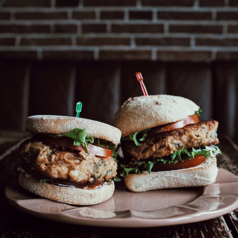 two hamburgers on a pink plate