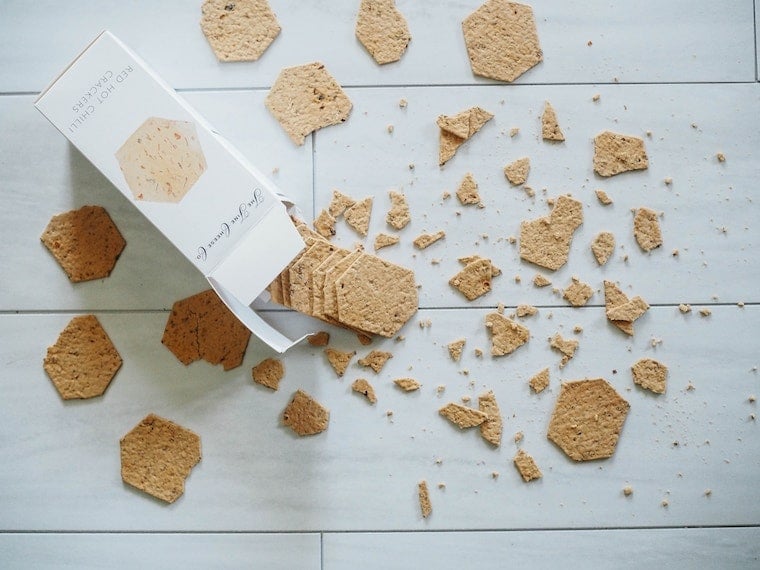 An overhead image of crackers fallen onto the floor, some broken.