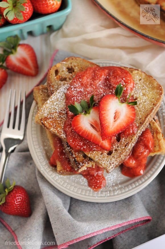 Vanilla french toast with strawberry sauce topped with fresh strawberries. 