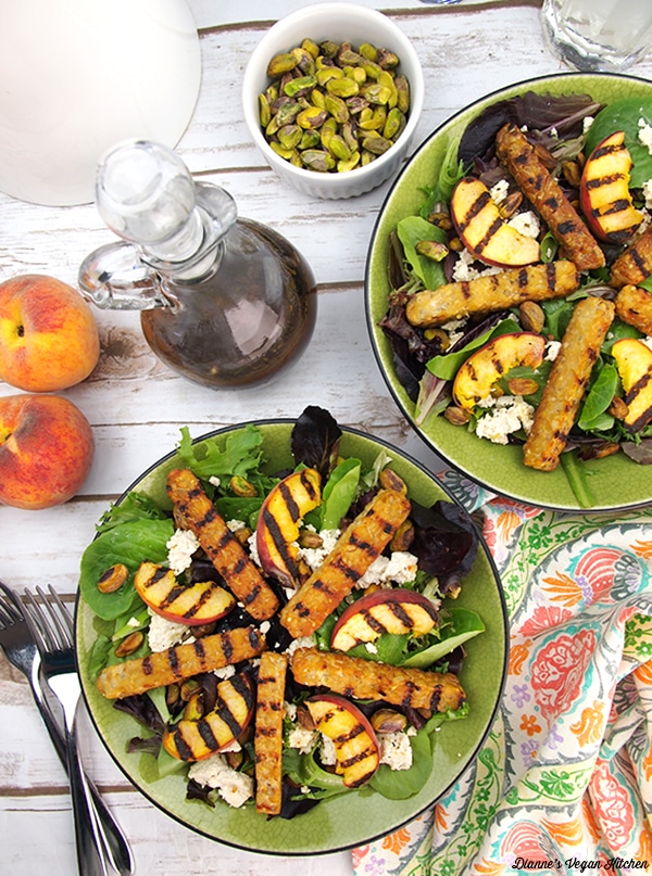 Grilled tempeh salad with peaches in a green bowl. 