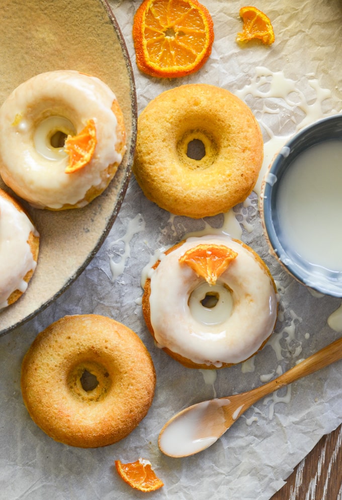 An overhead photo of a variety of orange olive oil baked donuts.