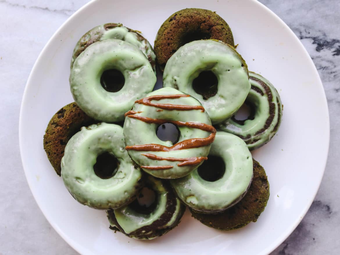 An overhead photo of a plate of baked coconut matcha donuts.