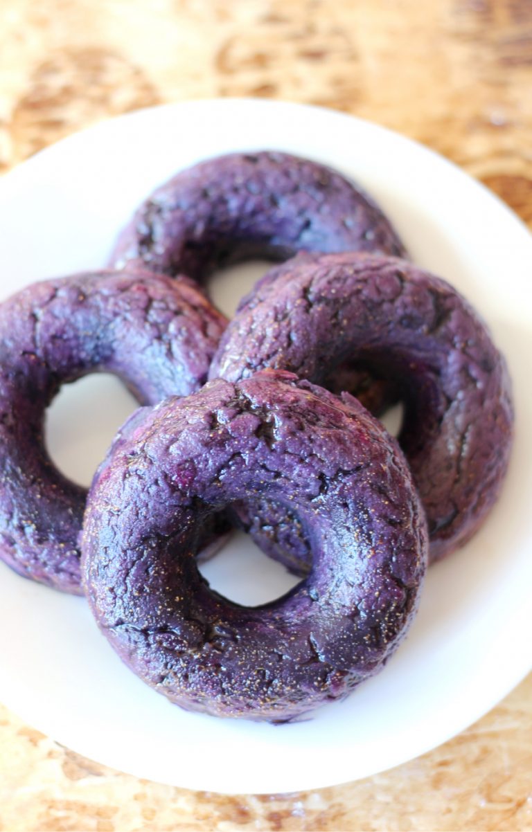 Four ginger glazed purple sweet potato donuts.