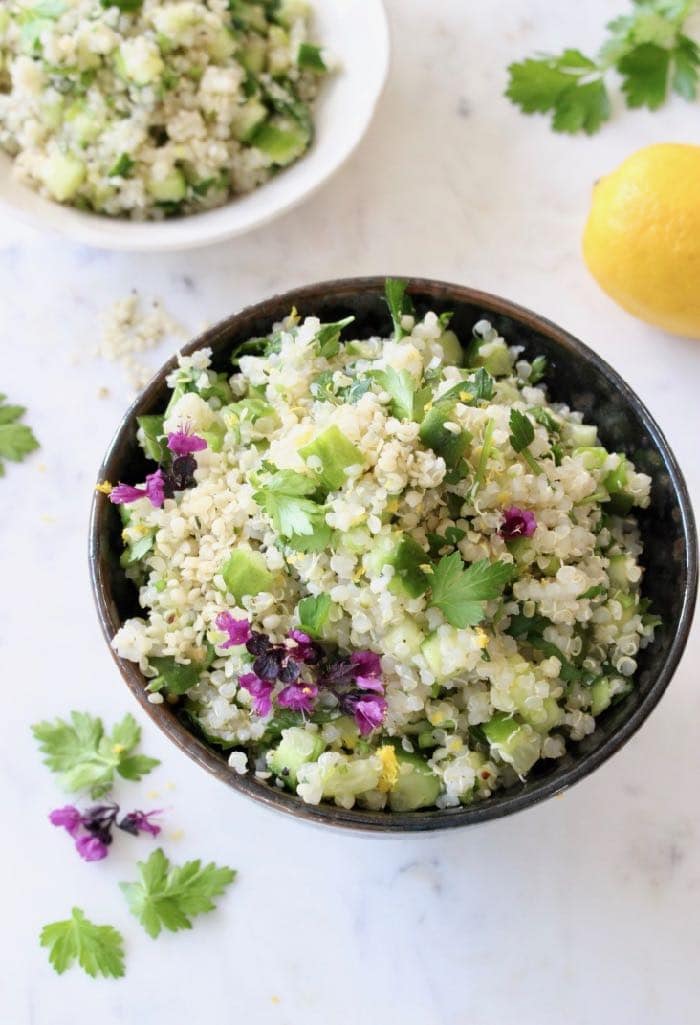 Lemon quinoa cucumber salad in a black bowl. 