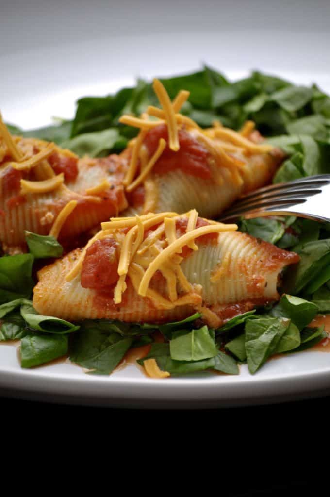 Tofu ricotta stuffed shells on a bed of greens. 