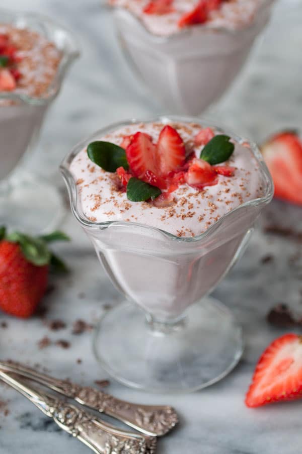 Strawberry mousse in a large glass topped with strawberries. 