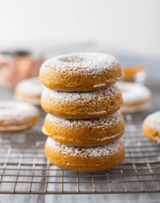 Four whole wheat turmeric honey donuts stacked on top of each other.
