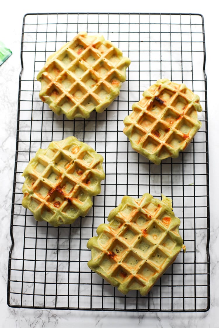 Matcha white chocolate waffles on a rack. 