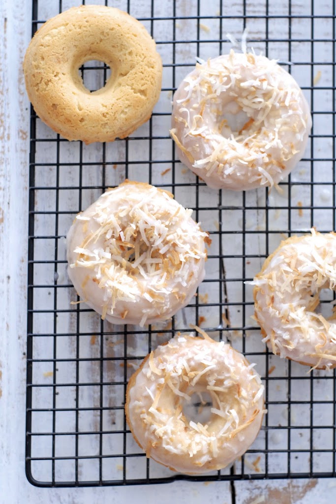 Five coconut donuts on a cooling rack.