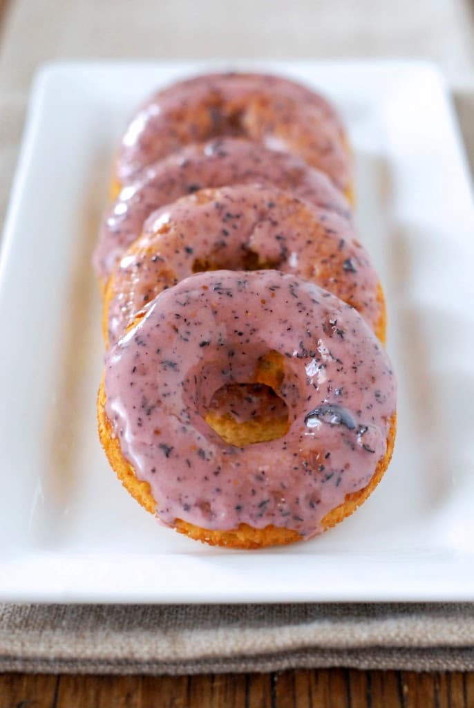 A close up of early grey donuts with blueberry glaze.