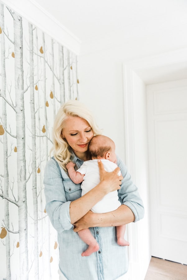 Abbey Sharp holding a baby discussing mom guilt.