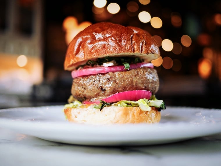 A burger on a white plate.