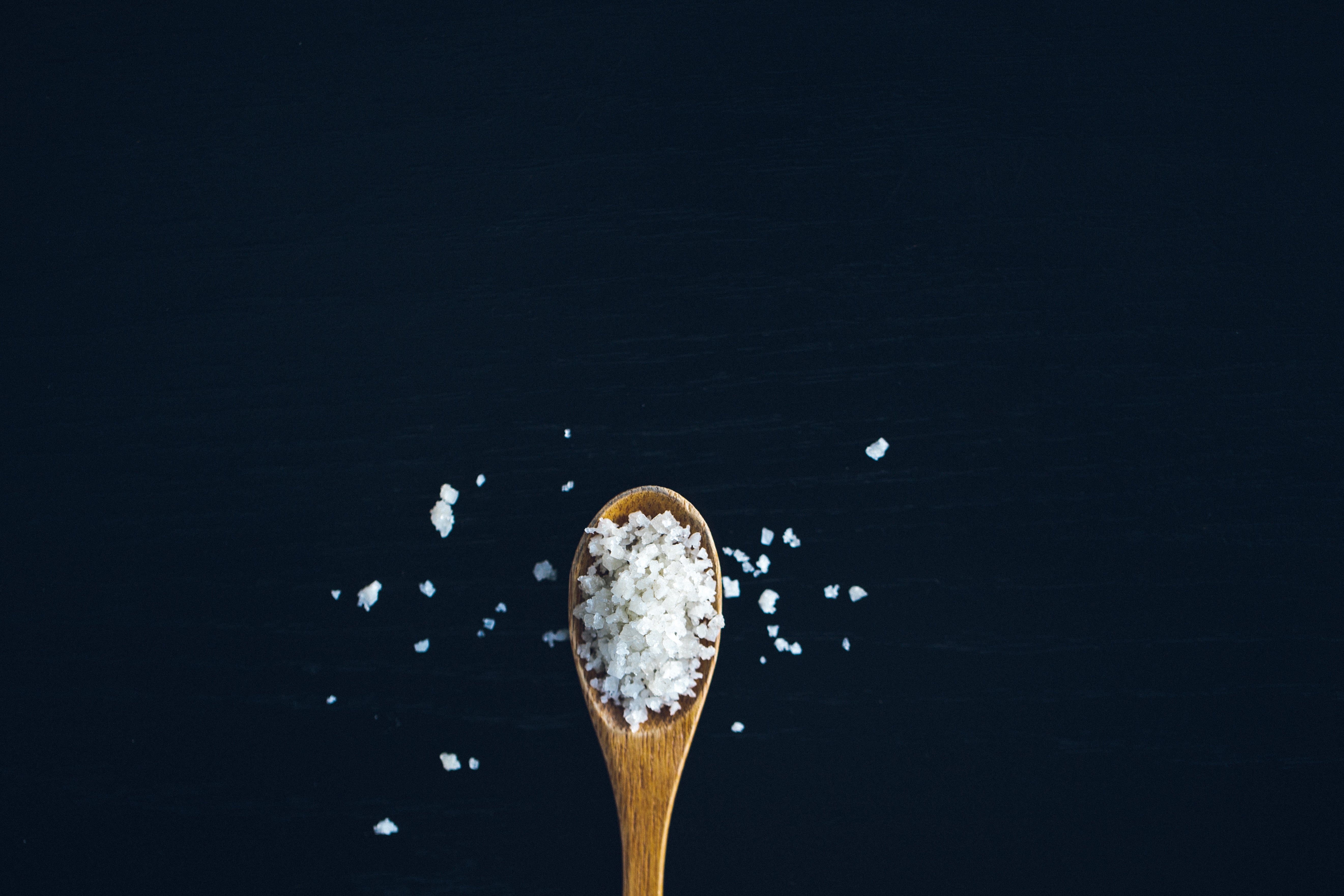 Coarse salt on small wooden spoon. 