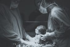 A baby held by hospital staff.