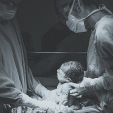 A baby held by hospital staff.