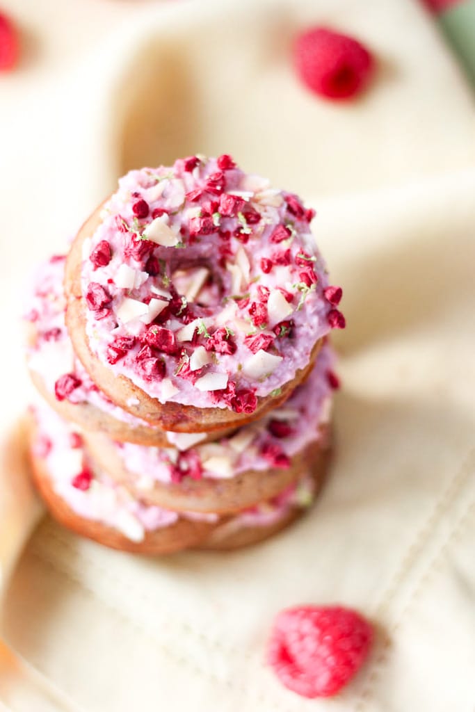 A close up of a stack of raspberry margarita donuts.