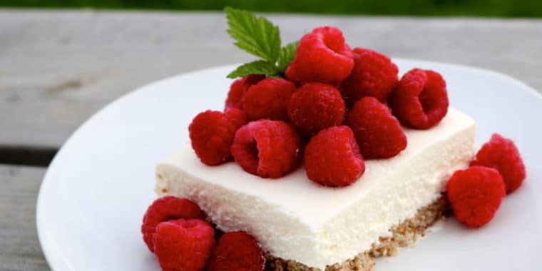 Raspberry cheesecake on a white plate.