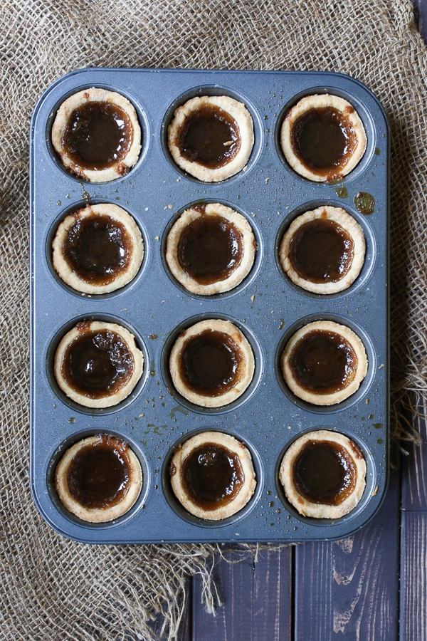 birds eye view of gluten free butter tarts in a muffin pan.