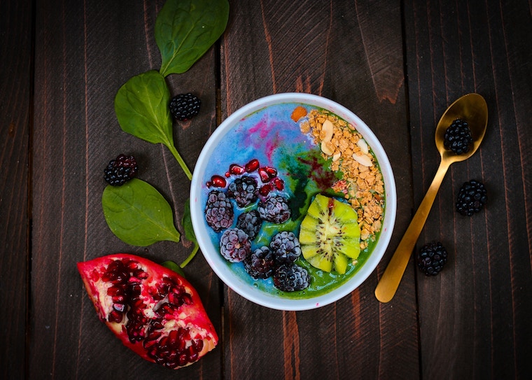 Overhead image of a smoothie bowl referring to the question "Can you diet while pregnant?".