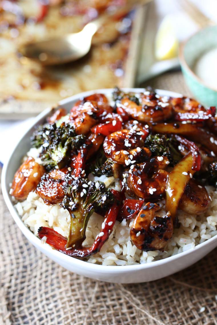 Close up of shrimp sheet pan dinner in a white bowl.