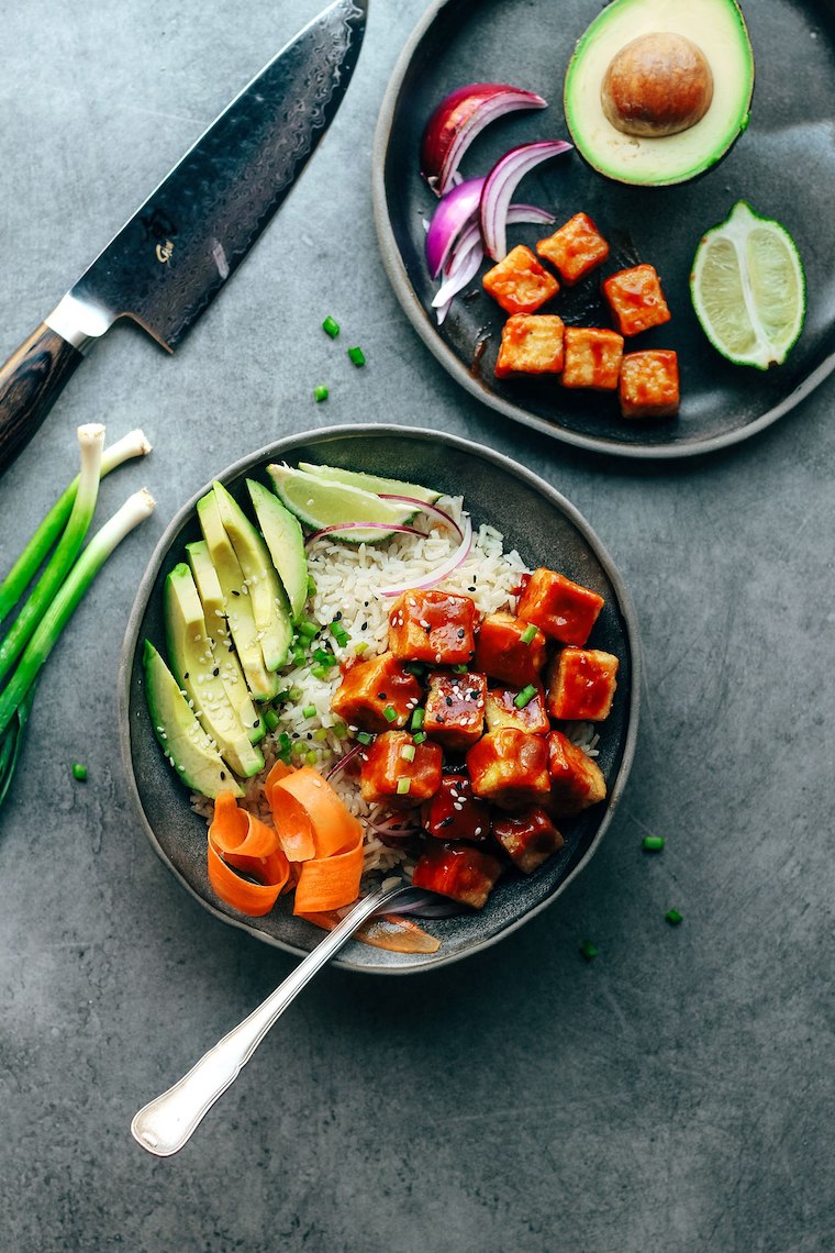 birds eye view of crispy sweet chilli tofu bowl with rice and avocado in a grey bowl